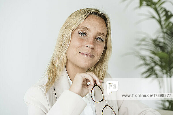 Portrait of businesswoman holding glasses