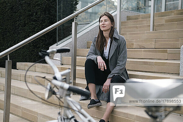 Thoughtful businesswoman sitting on steps