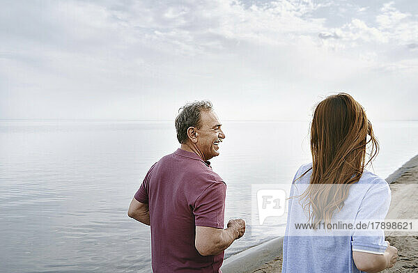 Älterer Mann und Frau joggen am Meer