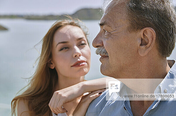 Contemplative senior man standing by daughter