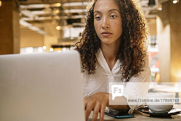 Determined businesswoman using laptop in office