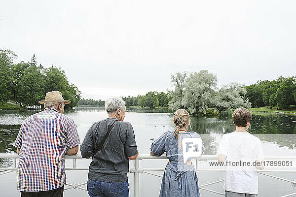 Älterer Mann und Frau mit Enkelkindern blicken auf den See