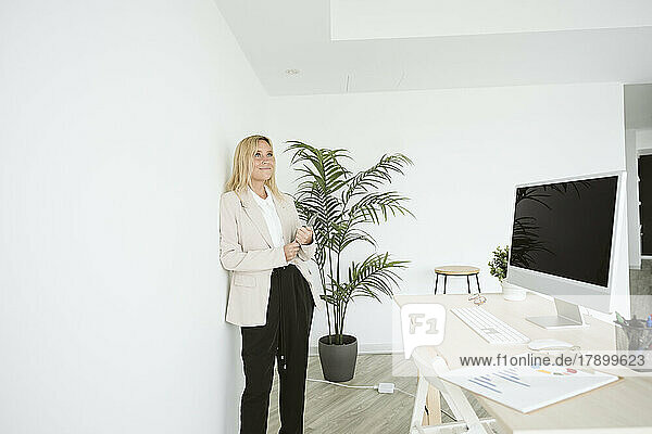 Businesswoman standing in office using tablet PC