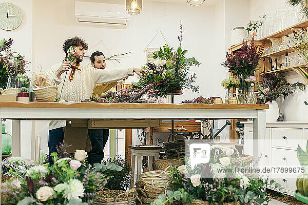 Salesmen arranging flowers of bouquet at floral shop