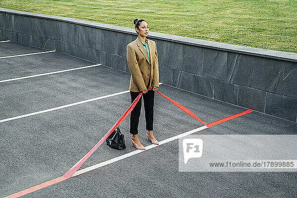 Businesswoman pulling red line at parking lot