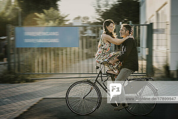Mann fährt Fahrrad  Frau sitzt am Griff