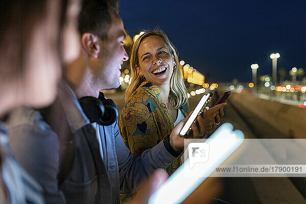 Cheerful woman enjoying with friends at night