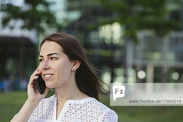 Smiling businesswoman taking on mobile phone