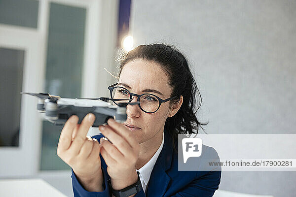 Geschäftsfrau mit Brille blickt auf Drohne