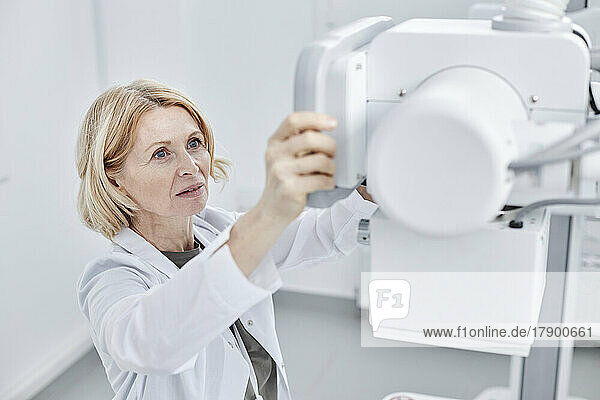 Doctor looking at X-ray machine in clinic