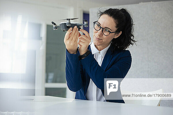 Businesswoman with eyeglasses looking at drone
