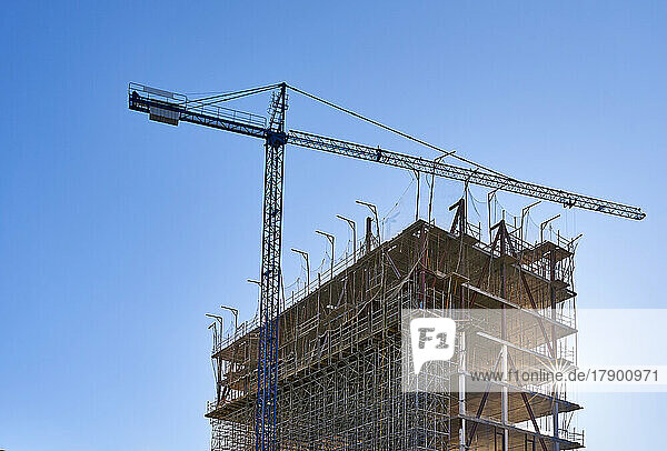 Crane standing in front of building under construction