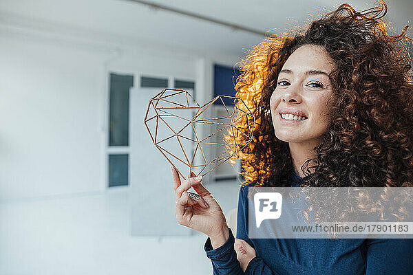 Smiling woman with heart shape model