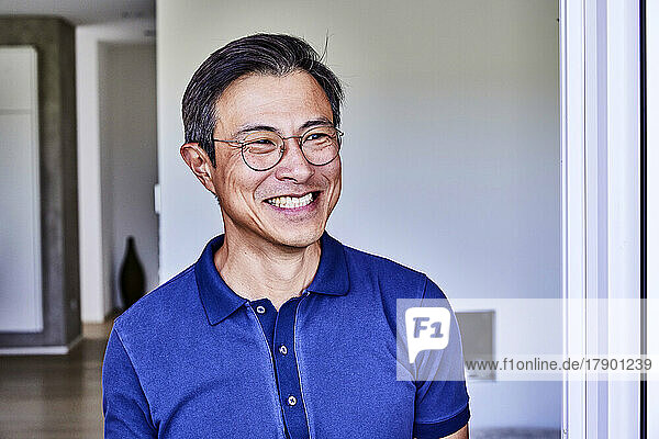 Happy mature man wearing eyeglasses at home