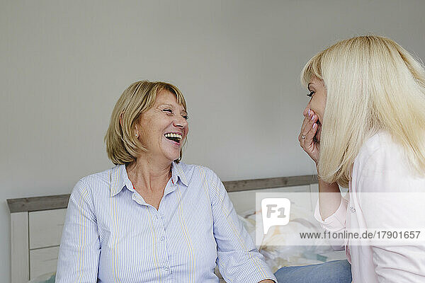Cheerful mother and daughter spending time together at home