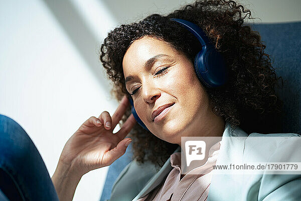 Businesswoman listening music and relaxing in office