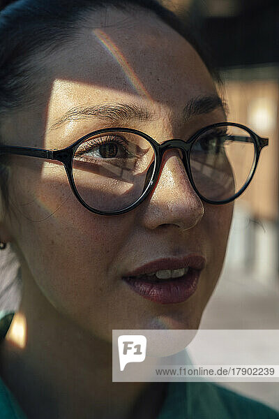 Businesswoman with sunlight on face wearing eyeglasses
