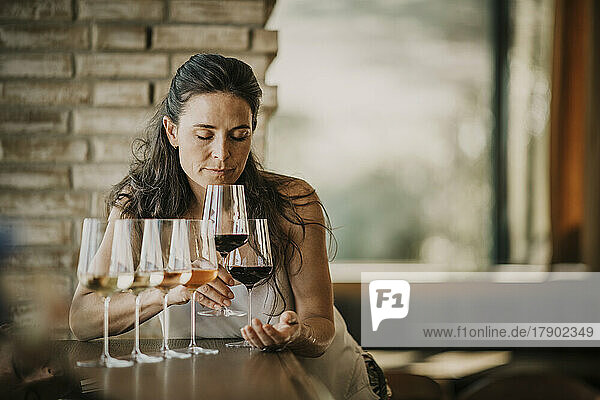 Woman with eyes closed smelling wine in restaurant