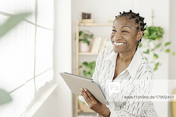 Smiling freelancer with tablet PC at home office