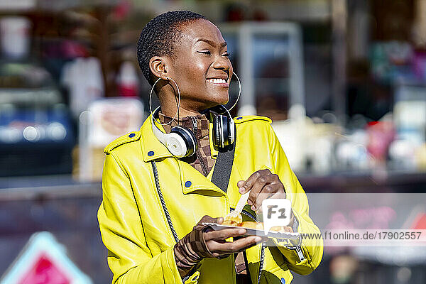 Woman with headphones having street food