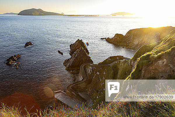 Irland  County Kerry  Blick auf den Hafen von Dunquin und die umliegenden Klippen bei Sonnenuntergang