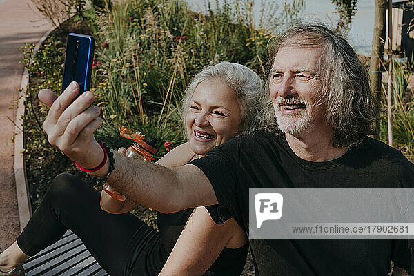 Glückliches Paar macht Selfie mit Smartphone im Park