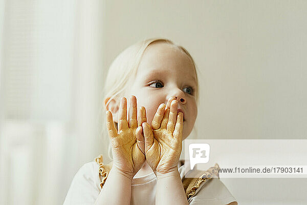 Cute girl with gold glitter on her palms