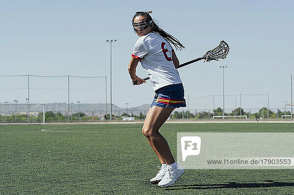 Player with lacrosse stick playing on sports field