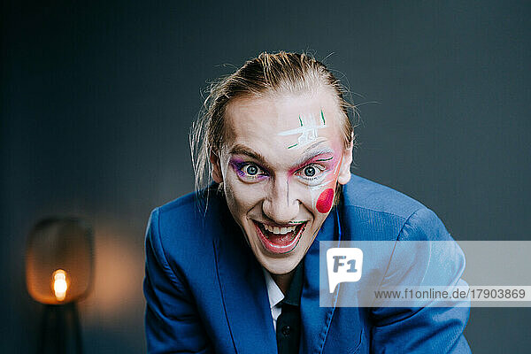 Cheerful young man clown make-up on face