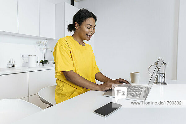 Woman working on a computer in the kitchen