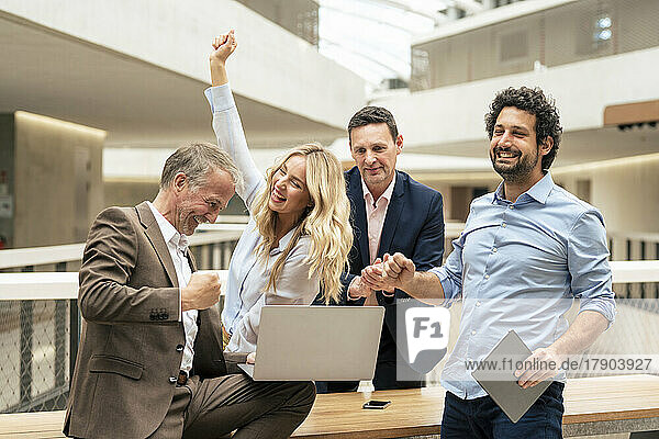 Fröhliche Geschäftskollegen feiern den Erfolg im Büro