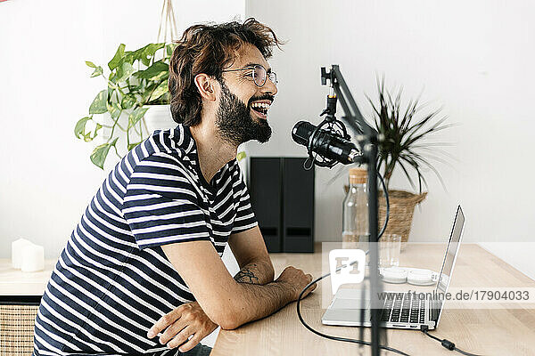 Glücklicher Inhaltsersteller  der Podcast im Heimstudio aufnimmt