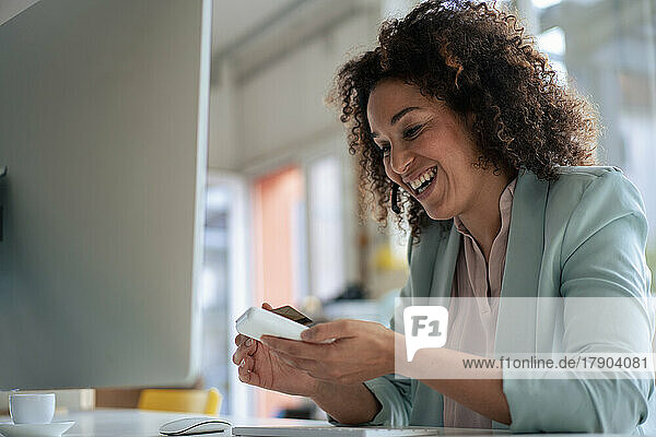 Happy businesswoman doing payment through credit card in office