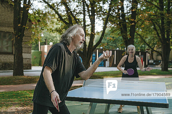 Couple playing table tennis in park