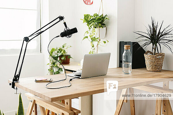 Laptop and microphone on table at home studio