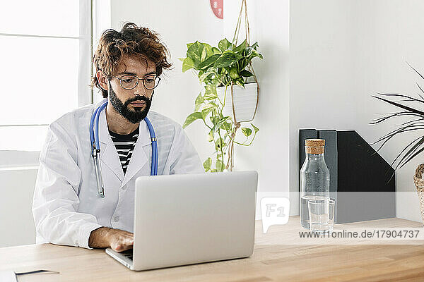 Doctor using laptop working from home office