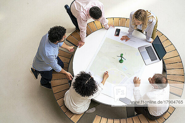 Geschäftsleute diskutieren miteinander über ein Diagramm auf dem Tisch im Büro