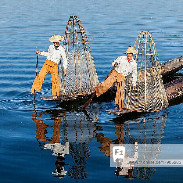 Myanmar travel attraction landmark  Traditional Burmese fishermen with fishing net at Inle lake in Myanmar famous for their distinctive one legged rowing style