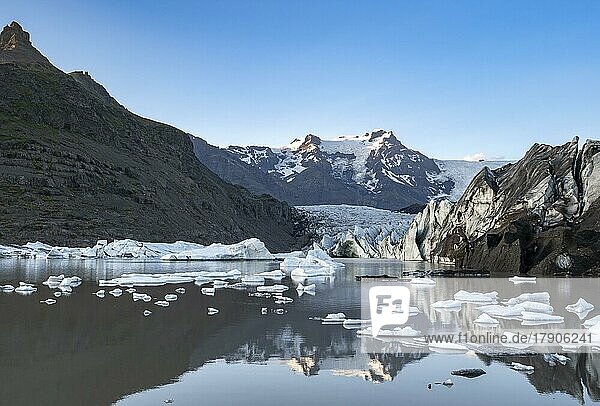 Spiegelung in der Gletscherlagune Svínafellslon mit Eisschollen  Gletscherzunge Svínasfellsjökull  hinten vergletscherter Berggipfel Hrútfjallstindar  bei Sonnenuntergang  Svínafell  Island  Europa