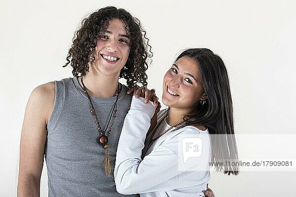 Portrait of a young couple dressed in yoga clothes looking ti the camera white background. Studio shot