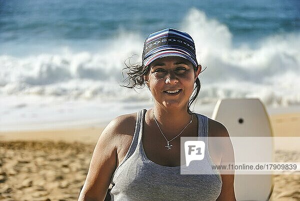 Porträt einer lächelnden Frau  die am Strand in die Kamera schaut  Hawaii  USA  Nordamerika