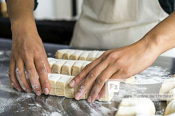 Nahaufnahme der Hände einer Bäckerin bei der Herstellung von Gebäck