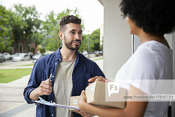 Delivery man talking with African American female customer