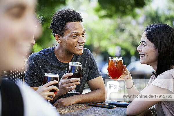 Latin American man enjoying a beer with friends