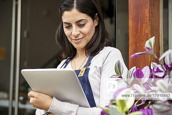 Garden center owner taking inventory on digital tablet