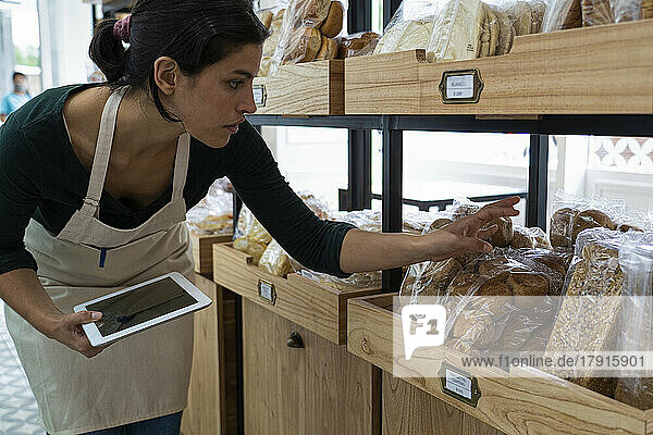 Aufnahme einer lateinamerikanischen Bäckereibesitzerin  die die Preise ihrer Waren überprüft