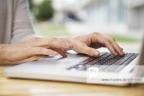 Close-up shot of woman's hands typing on a laptop computer