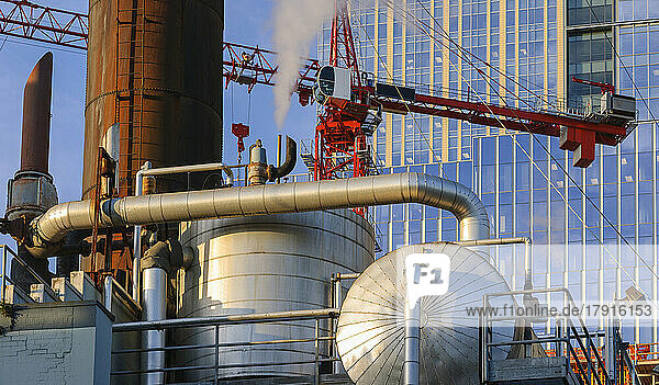 Ein Industriekraftwerk  große Metallbehälter  Dampf  der erzeugt wird und aufsteigt  Rohrleitungen.