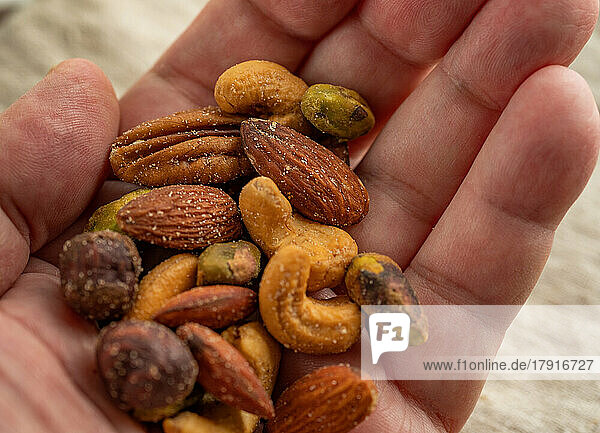 Portion of assorted nuts in palm of hand