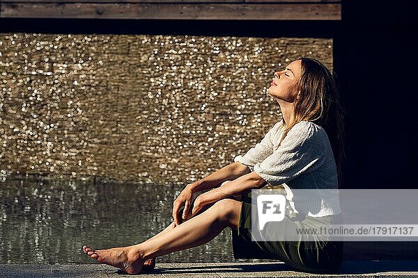 Mädchen entspannen unter der Sonne in der Nähe des Wassers in schwülen heißen Tag